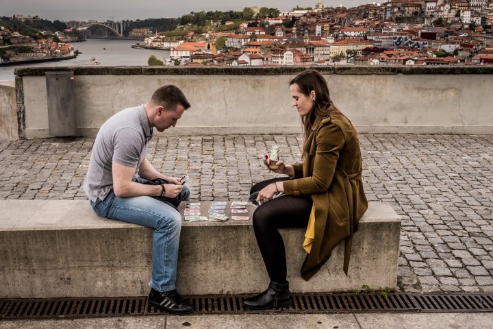 Playing cards with Porto city behind